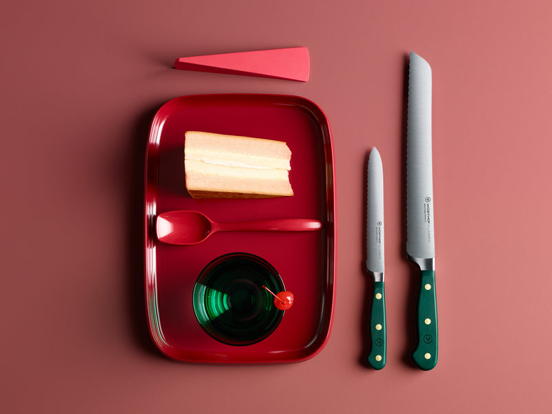 Red tray with sliced bread, a knife, and a fork on a red background