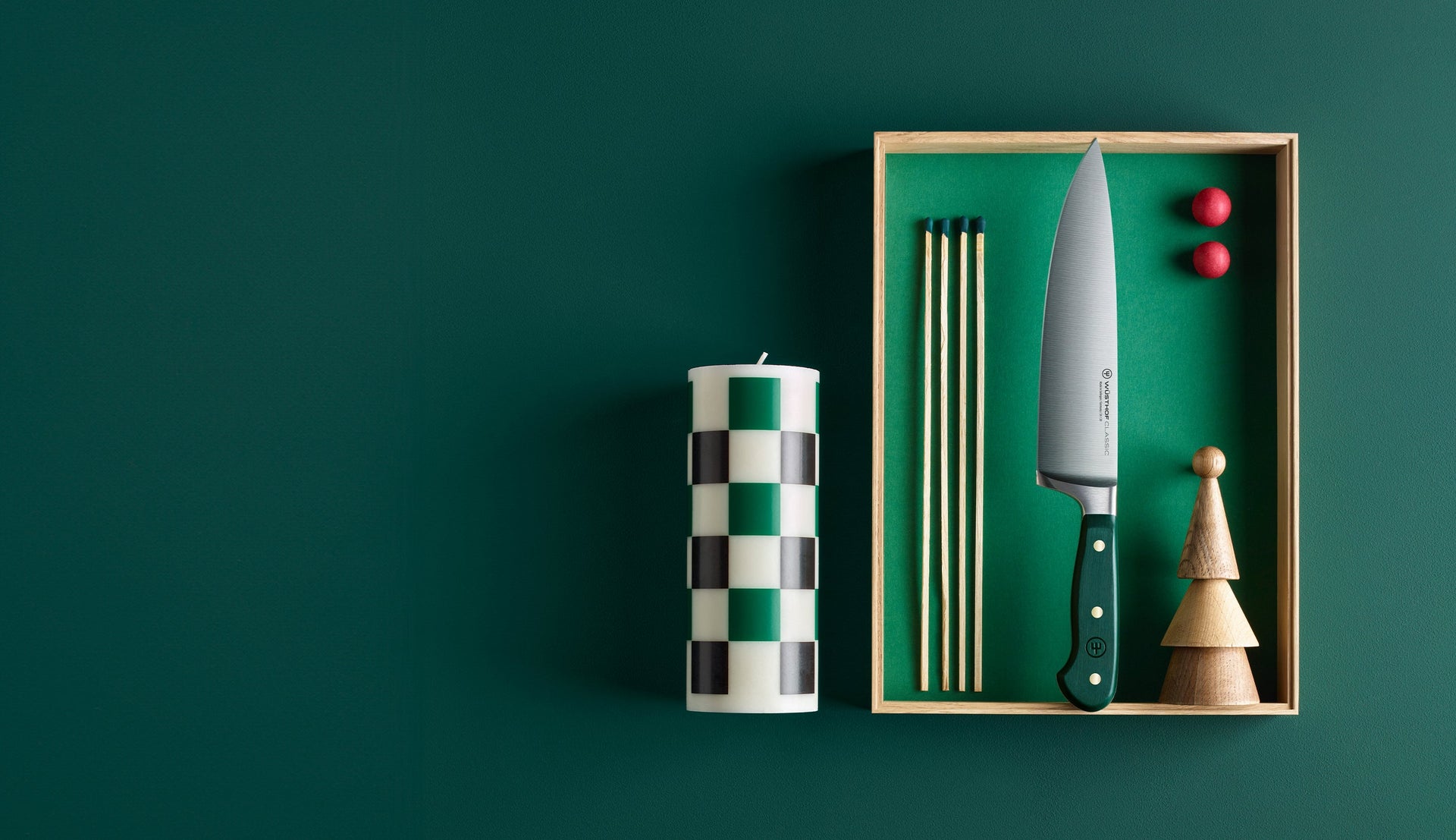Candle, knife, and other items in a box on a green background