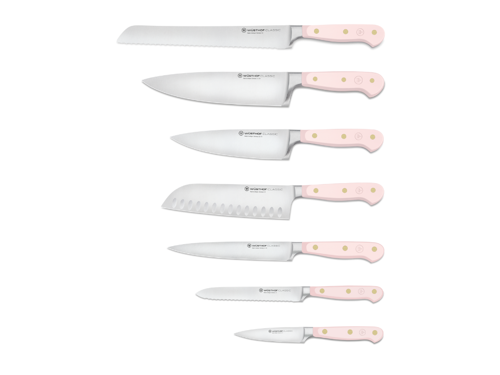 Six kitchen knives with pale pink handles featuring three brass rivets each and polished stainless steel blades for versatile culinary tasks.