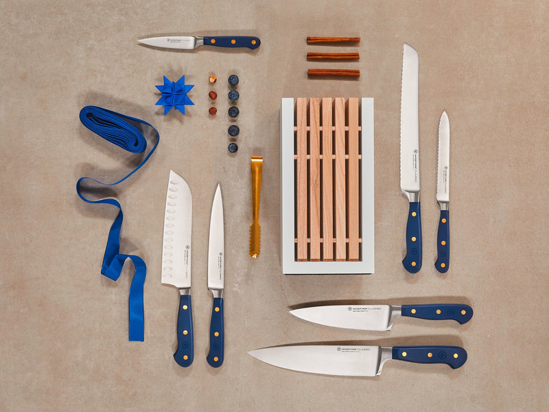 Collection of knives with blue handles on a beige background